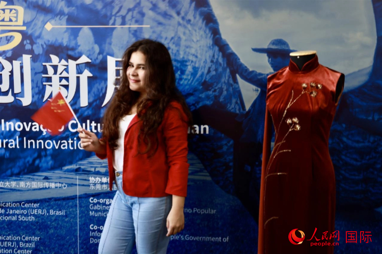 主题展览和文化体验活动现场,一名手持中国国旗的里约市民与中国传统服饰合影留念。人民网记者宋亦然摄