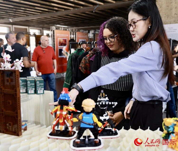 中方工作人员为现场观众讲解展品背后的文化和历史故事。人民网记者 宋亦然摄